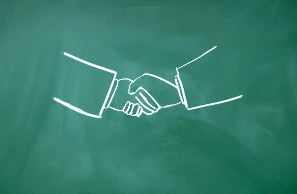 Abstract Shake hands symbol drawn with chalk on blackboard — Stock Photo, Image