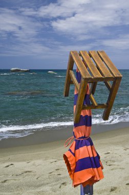 Closed parasols orange on the beach of the island of Ischia cita clipart