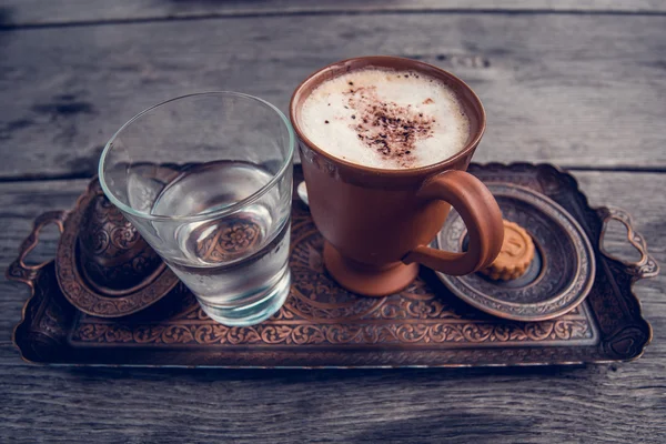 Xícara de café, um copo de água e biscoitos na mesa de madeira . — Fotografia de Stock
