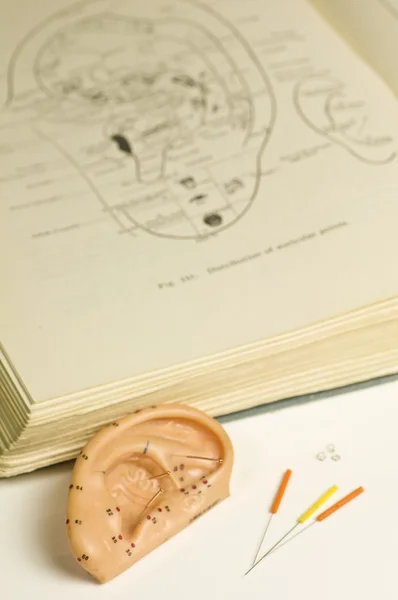Kulak akupunktur modeli, ders kitabı ve akupunktur iğneleri — Stok fotoğraf