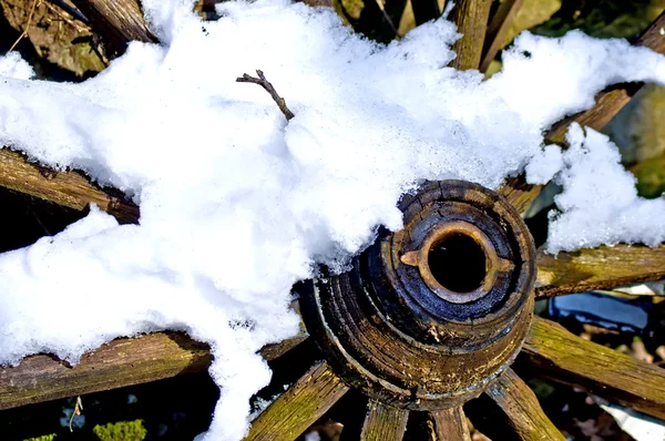 Старое колесо в снегу — стоковое фото