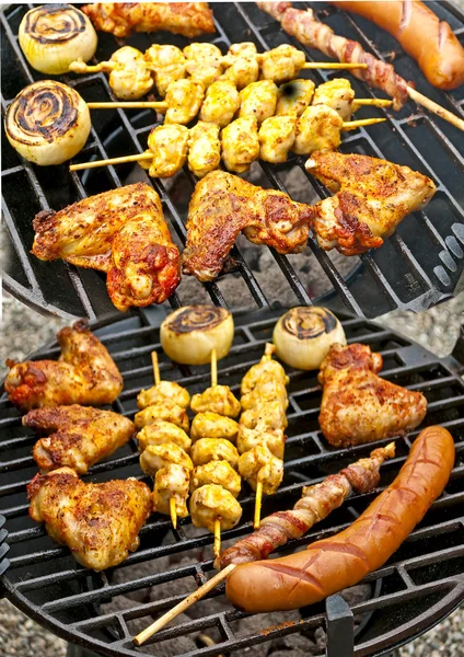 Churrasco com asas de frango, Bratwurst, espeto de carne e presunto — Fotografia de Stock