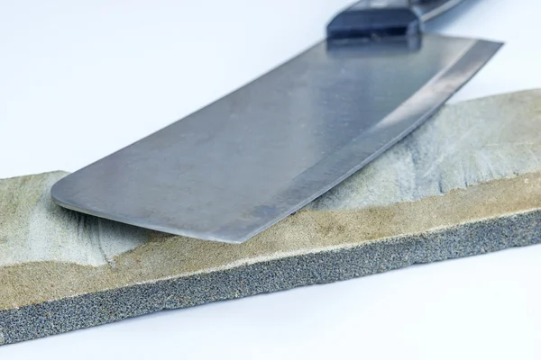 Sharping stone with a kitchen axe — Stock Photo, Image