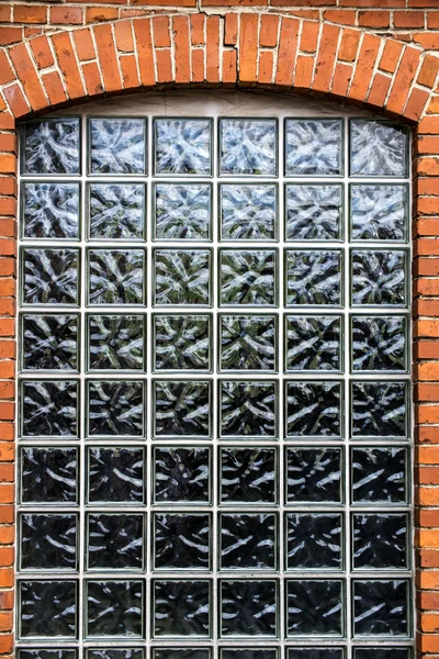 Wall of small bricks with a window — Stock Photo, Image