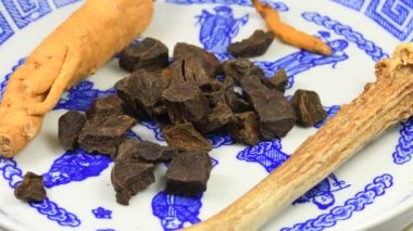 Tırtıl mantarı, boynuz boynuzu, yumru fleeceflower ve sehpanın üzerinde ginseng kökü.