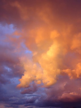 Gökyüzünde dramatik fırtına bulutları. Sıcak çalkantılı turuncu gün batımı.