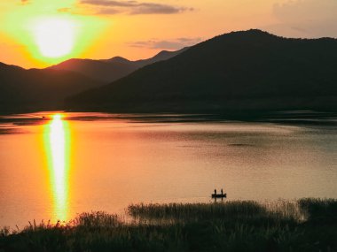 Büyük güneşi olan küçük bir balıkçı. günbatımı manzarası.