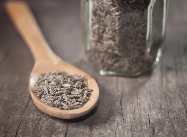 Semillas de comino indio en una cuchara en la mesa — Foto de Stock