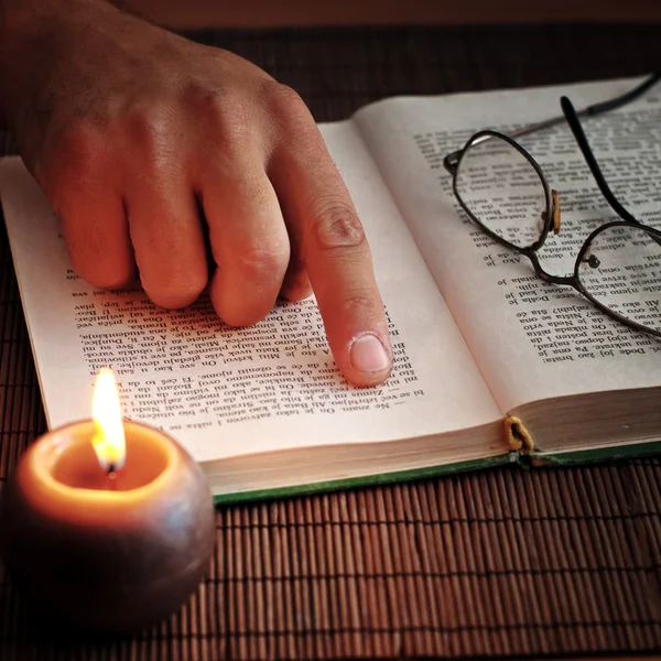 Un vecchio libro aperto a lume di candela , — Foto Stock