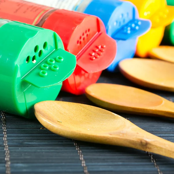 Wooden spoons and bottles with spices — Stock Photo, Image