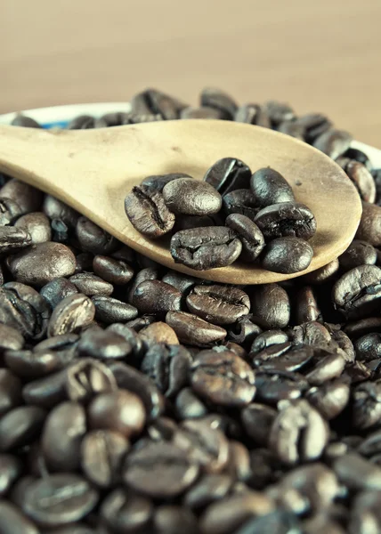 Grains de café avec cuillère en bois close-up — Photo