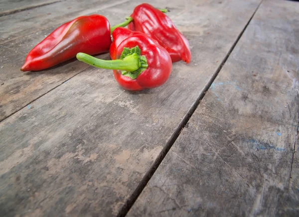 Roter Paprika auf altem Holztisch — Stockfoto