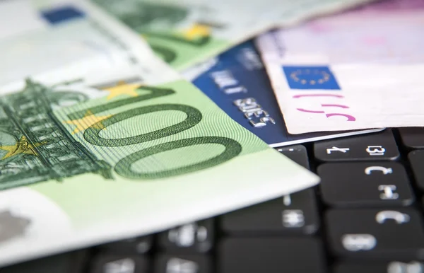 Black laptop keyboard with 100 euro bills — Stock Photo, Image