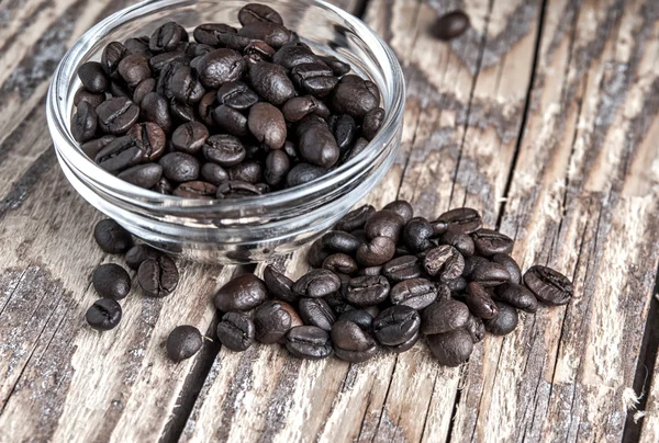 Coffee beans on old wooden table — Stock Photo, Image