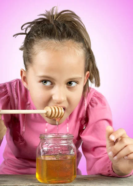 Niña comer miel — Foto de Stock