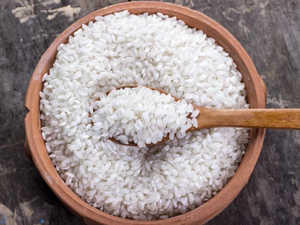 Рис на миске и деревянной ложке — стоковое фото