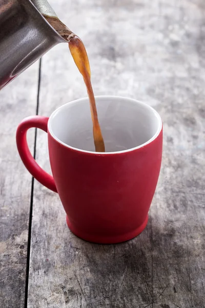 Derramando uma xícara de café fresco — Fotografia de Stock