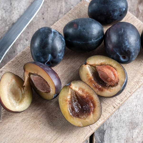 Plums on a wooden kitchen board — Stock Photo, Image