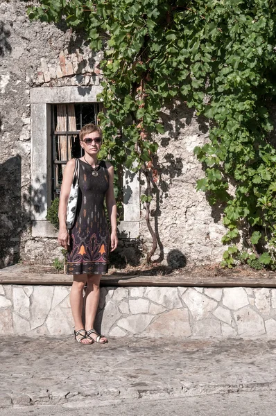 Femme devant un vieux mur de pierre — Photo