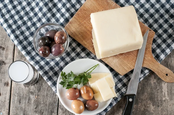 Вкусный сыр и оливки на столе — стоковое фото