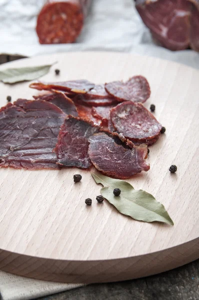 Droge salami worst gesneden op een houten bord — Stockfoto