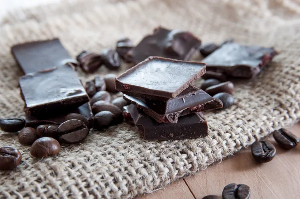 Morceaux de chocolat tour sur une surface en bois — Photo