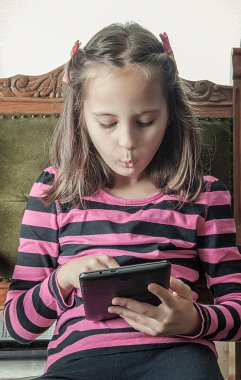 sandalyede oturan tablet ile küçük kız