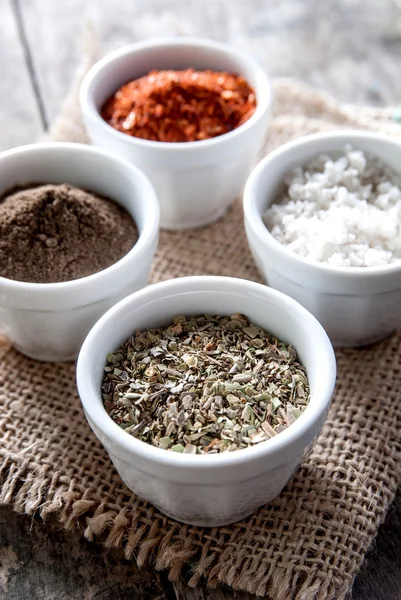 Pepper, oregano and cooking salt in bowls — Stock Photo, Image