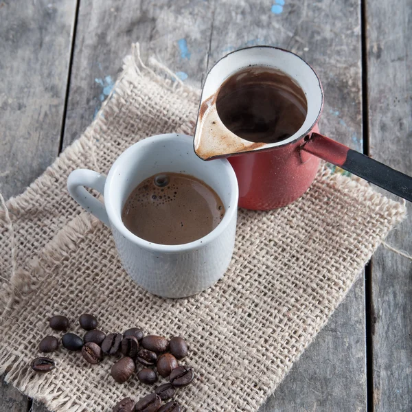 Xícara de café e panela em fundo de madeira — Fotografia de Stock