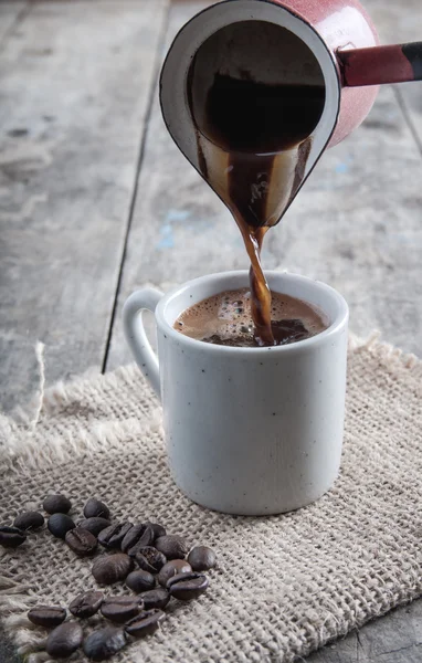 Xícara de café e panela em fundo de madeira — Fotografia de Stock