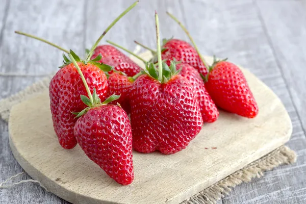 Fresas en una tabla de cortar de madera —  Fotos de Stock