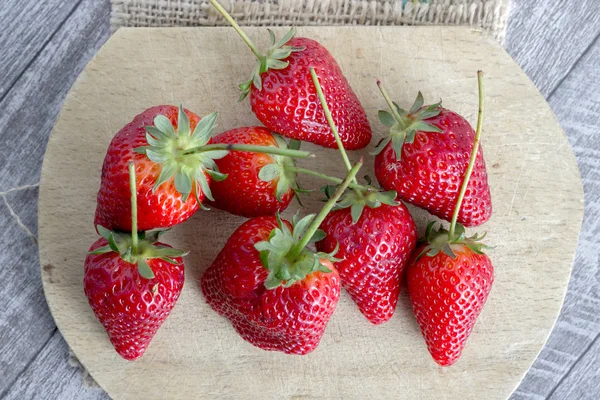 Fresas en una tabla de cortar de madera — Foto de Stock