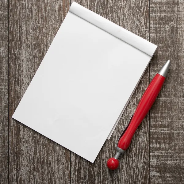 Blank notepad and pen on  wooden table