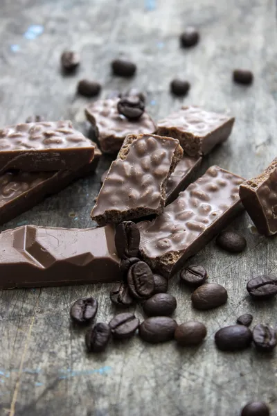 Chokladkakor och kaffebönor på träbord — Stockfoto