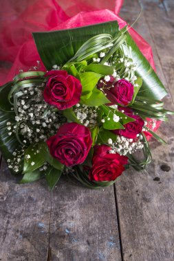 ahşap bir masaya uzanmış güller