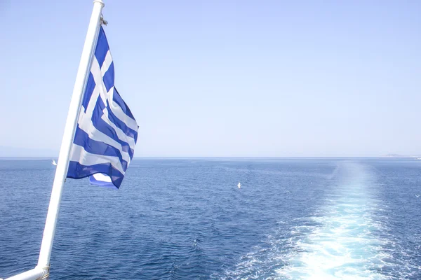 Греческая лодка с флагом на море — стоковое фото