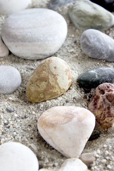 Havet stenar insamling på sand bakgrund — Stockfoto