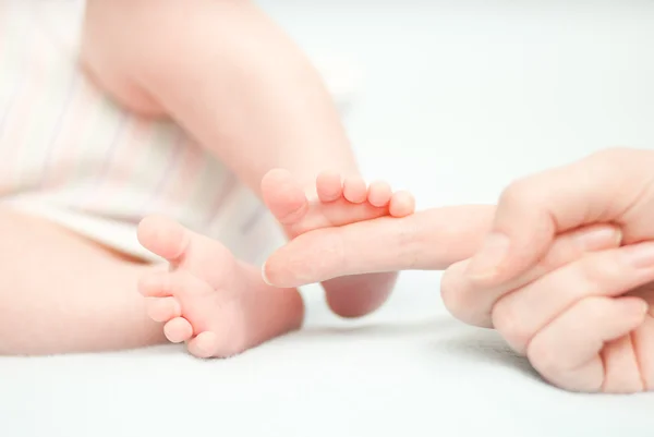 Kleine baby voeten en de hand van de moeder — Stockfoto