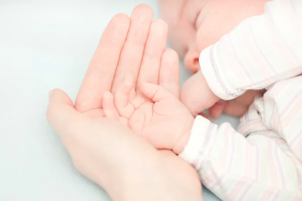 Kleine baby handen en hand van de moeder — Stockfoto