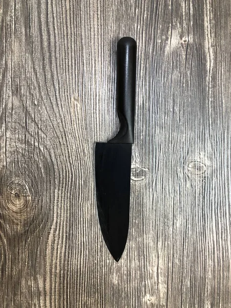 Черный Нож Лежит Столе Деревянной Текстурой Закрыть Изображение Черного Ножа — стоковое фото