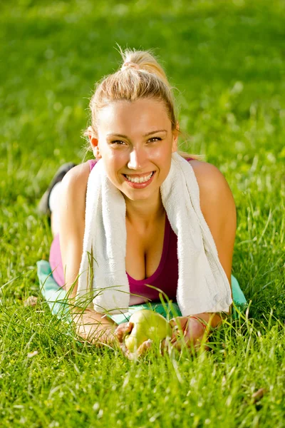Mooi meisje liggen op het gras met een witte handdoek rond zijn — Stockfoto