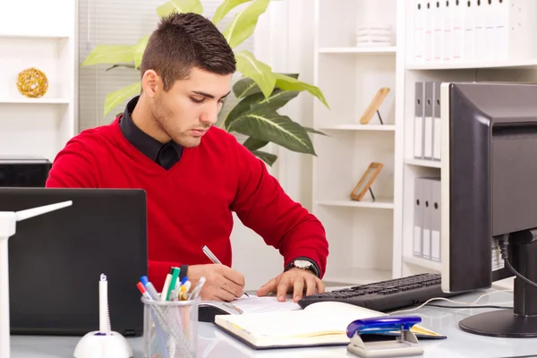 Moderno giovane uomo d'affari che lavora in ufficio, seduto alla scrivania, scri — Foto Stock