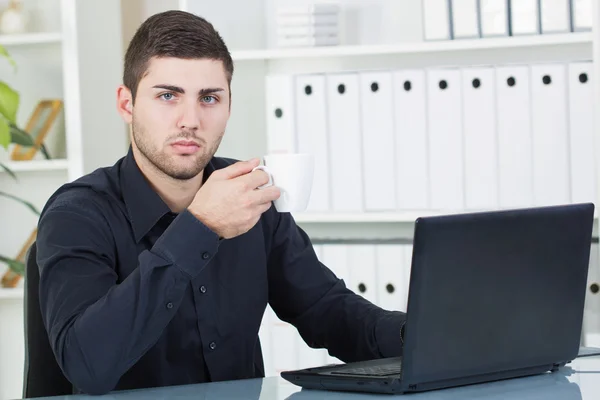 Uomo d'affari bere caffè nel suo ufficio — Foto Stock