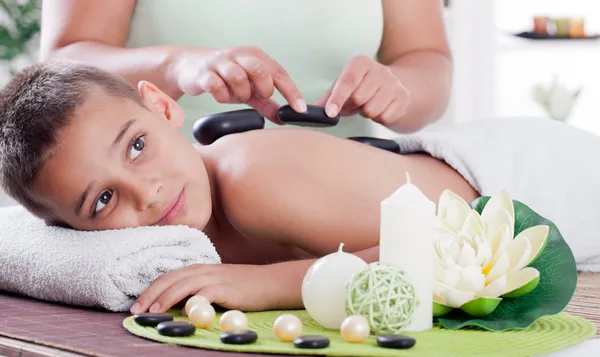 Terapeuta masajeando a un niño en el salón de spa — Foto de Stock