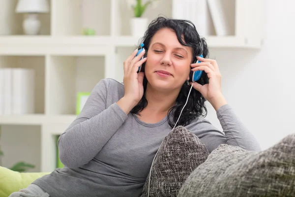 Beautiful smiling woman listening music — Stock Photo, Image