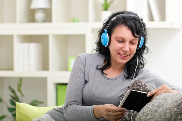 Vakker, smilende kvinne lytter til musikk – stockfoto