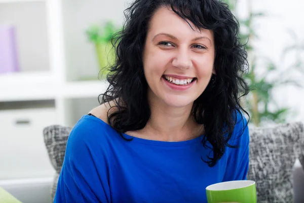 Genç kadın, evde içecek kahve ve rahatlatıcı — Stok fotoğraf