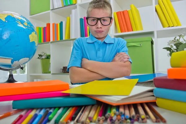 Enojado y cansado colegial estudiando con un montón de libros en su d — Foto de Stock