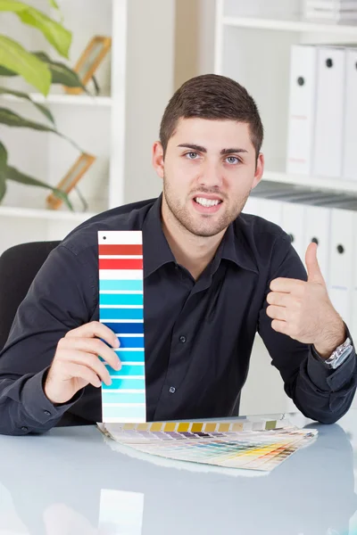 Exitoso hombre de negocios mostrando paletas de colores — Foto de Stock