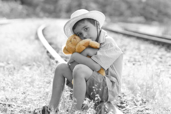 Weggelopen kind aan spoorweg knuffelen zijn teddybeer — Stockfoto